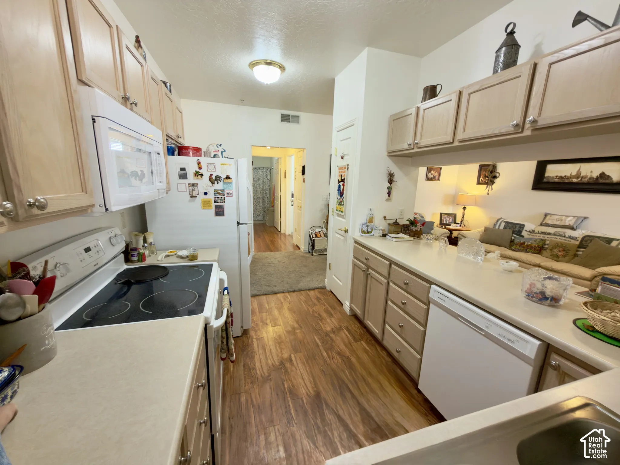 Kitchen featuring laminate flooring, light-colored cabinetry, a built-in microwave, an electric range, and a new dishwasher