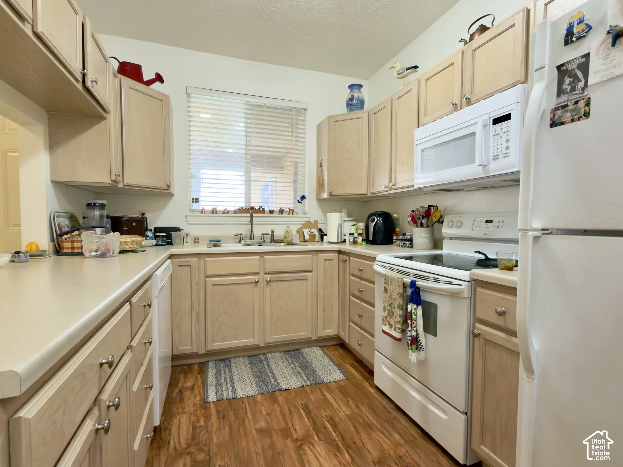Kitchen featuring laminate flooring, light-colored cabinetry, a built-in microwave, a new dishwasher, and a window with mountain views