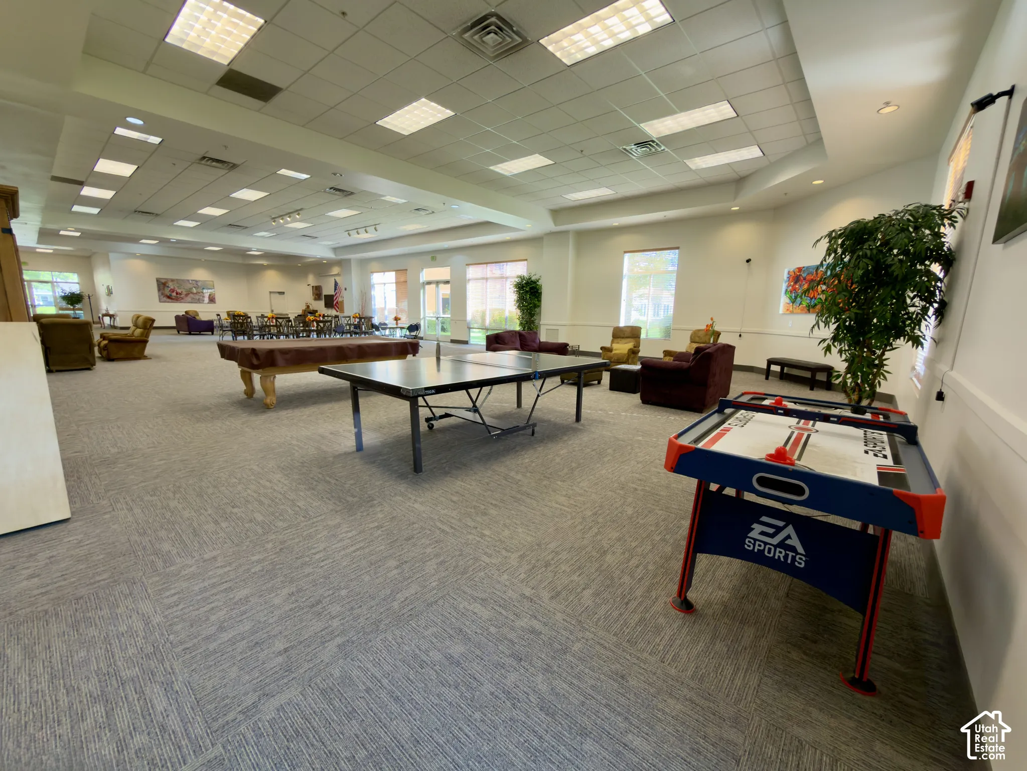 Spacious common area featuring game tables, couches, tables & chairs