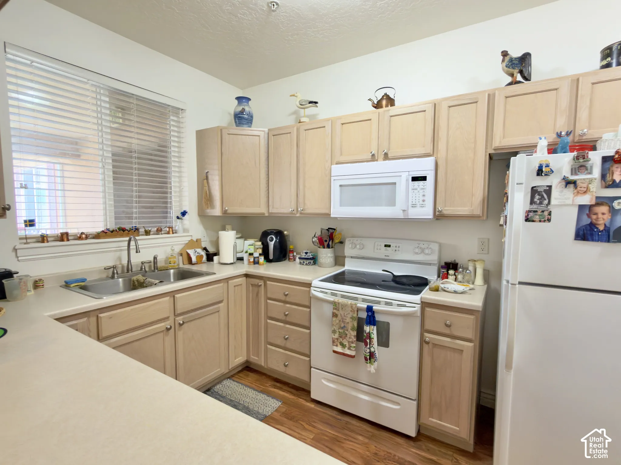 U-shaped kitchen featuring lots of wood-finish cabinetry & laminate flooring
