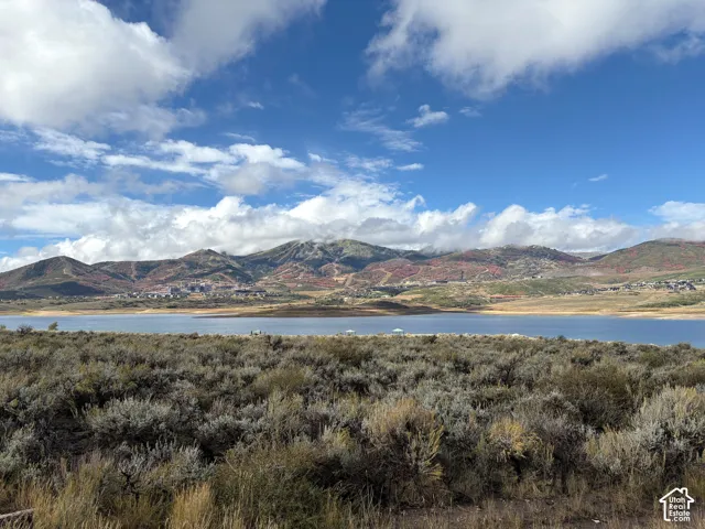 Expansive natural landscape with a large body of water, distant mountains, and a clear sky