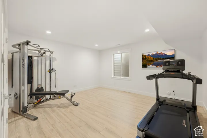 Light wood-finish flooring with white walls and recessed ceiling lighting