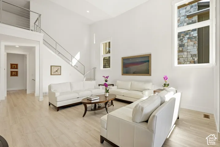 Vaulted ceilings, light wood-finish flooring, and modern cable-rail staircase
