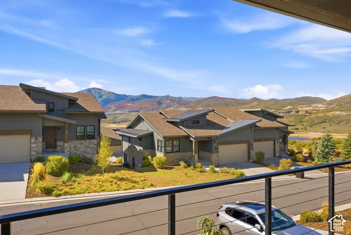 Modern residential architecture with a stone and siding exterior, multi-pitch rooflines, and an attached two-car garage