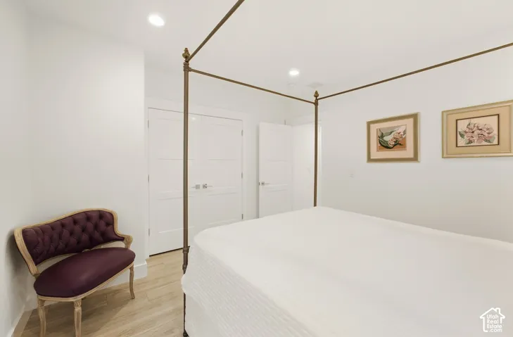 Recessed lighting illuminates wood-finish flooring and multiple panel doors