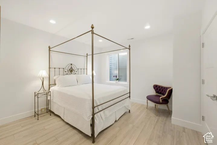 Recessed ceiling lighting, light wood-finish flooring, and a white interior door with contemporary hardware