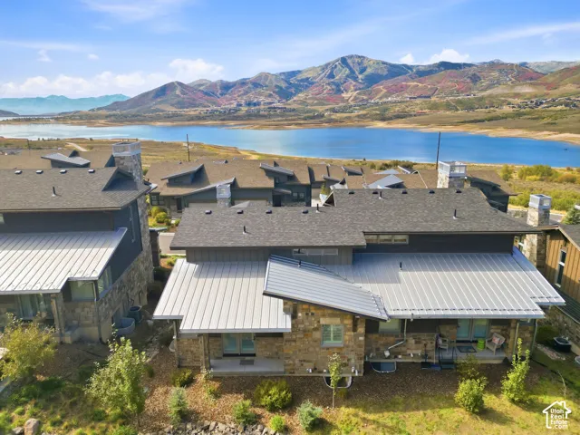 Multiple structures featuring stone and siding exteriors, composite shingle roofing, and metal roofing elements