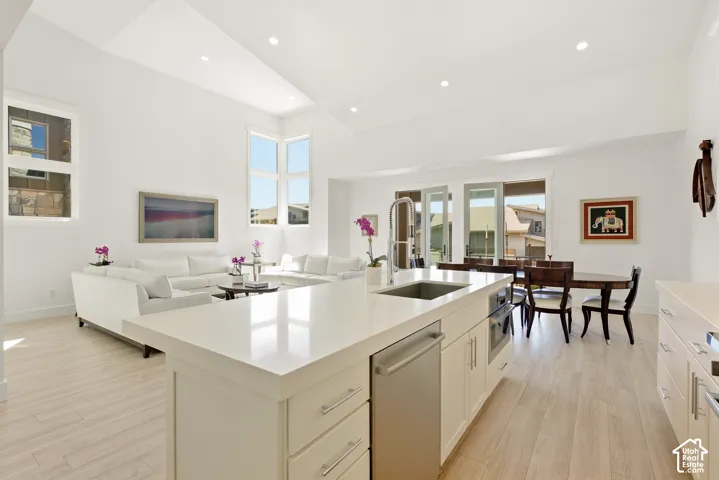 Open-concept living area with vaulted ceilings, recessed lighting, and light wood-finish flooring