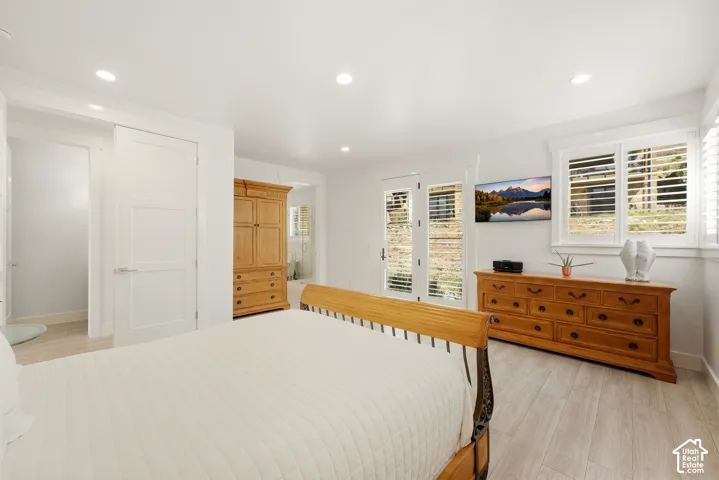 Recessed lighting illuminates the room, featuring light wood-finish flooring and white interior doors