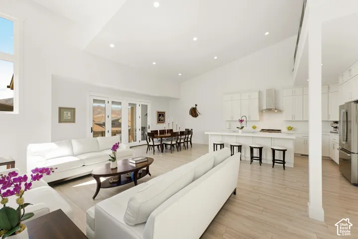 Vaulted ceilings, recessed lighting, and light wood-finish flooring