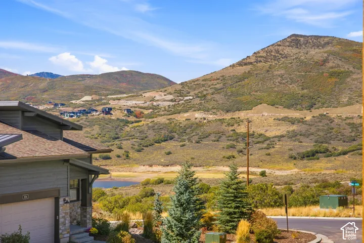 Crafted with stone and siding facade, featuring a shingled roof and a visible garage
