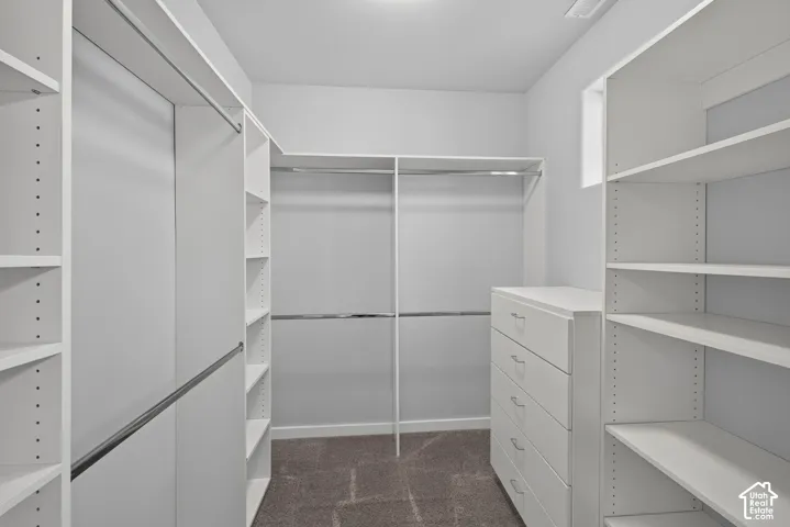 Integrated shelving system with multiple hanging rods, built-in drawer cabinet, recessed lighting, and a window for natural illumination
