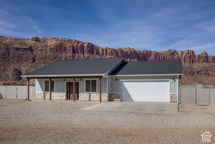 Contemporary exterior featuring light-colored siding, stone accents, and a dark shingle roof