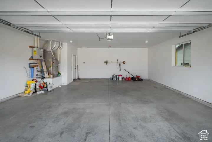 Attached garage with a concrete floor, white walls, and a window for natural light