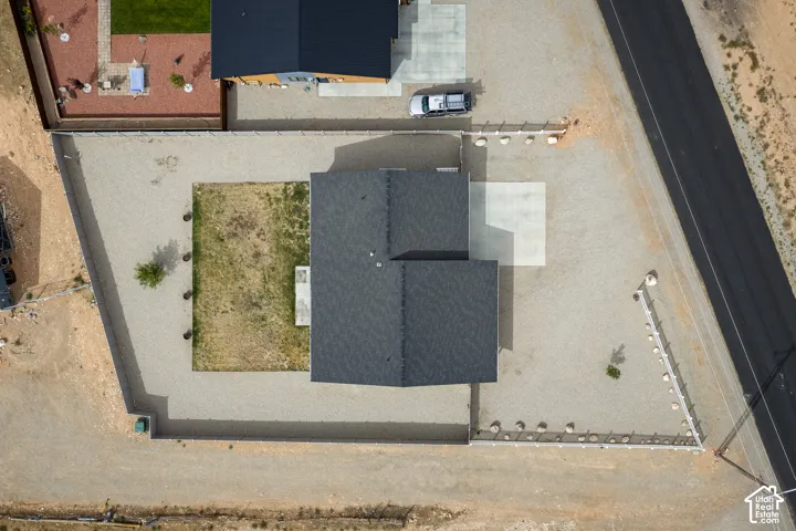 Gravel perimeter with partial fencing and a small green space