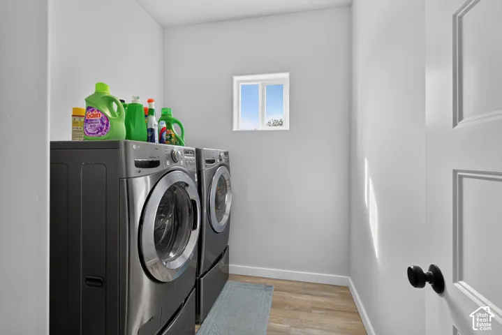 Dedicated laundry area with light wood-finish flooring