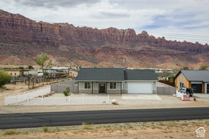 Single-story residence featuring a dark shingle roof, light-colored siding, and stone accents