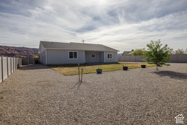 Single-story property featuring light gray siding and a dark gray shingle roof