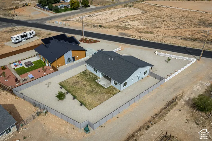 Expansive gravel lot with a fully fenced perimeter, paved driveway, and dedicated parking space