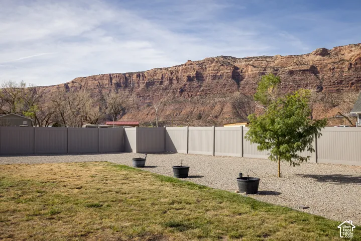 Expansive outdoor space featuring a partial lawn, gravel landscaping, and a privacy fence