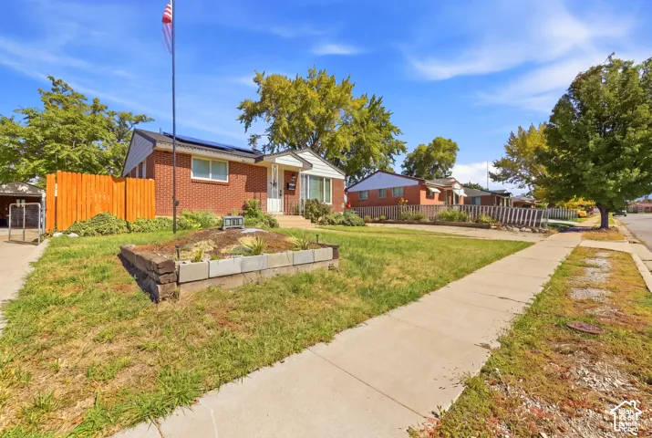 Brick exterior, solar panels, and a wood privacy fence