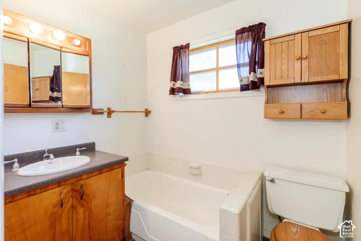 Built-in bathtub, wood-finish vanity with integrated sink, wood-finish medicine cabinet, wood-finish wall-mounted storage, and a single window