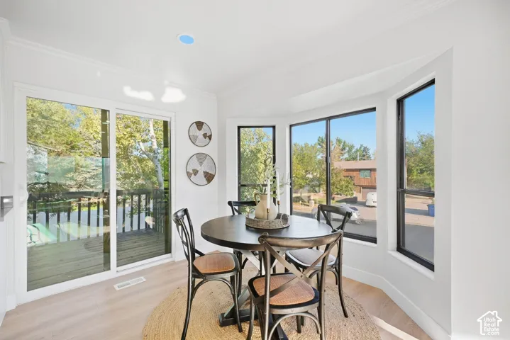 Bay window, sliding glass door, recessed lighting, crown molding, wood-finish flooring