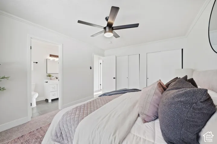 Crown molding, recessed lighting, matte black ceiling fan, white paneled closet doors, and wood-finish vanity with a rectangular sink