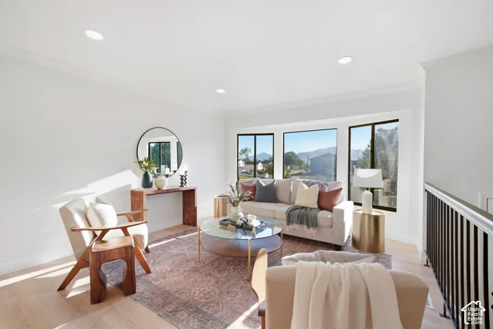 Recessed lighting illuminates the bright interior, featuring crown molding and light wood-finish flooring