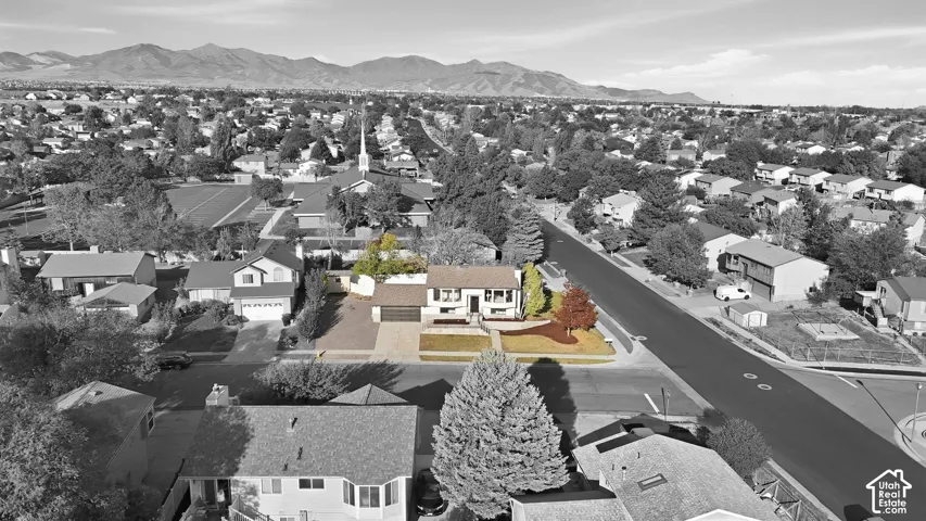 Single-family residence with an attached garage, front yard landscaping, and mature trees