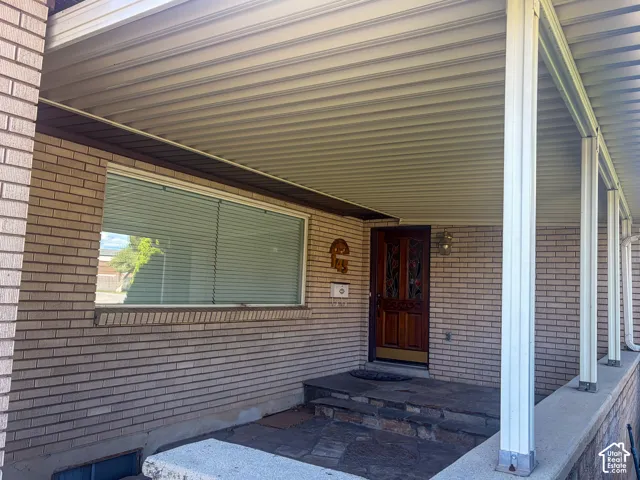 Front entrance with brick exterior and a covered porch