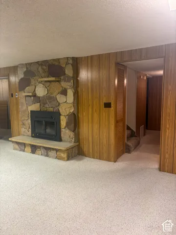 Stone-clad fireplace with a hearth in basement
