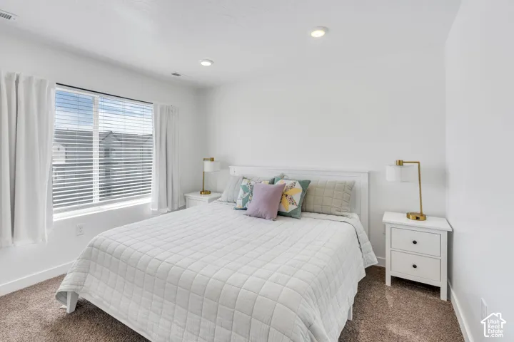 Recessed ceiling lighting, white window blinds, and carpeted flooring