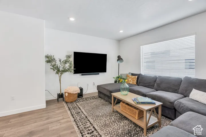Recessed lighting, wood-finish flooring, and white window blinds