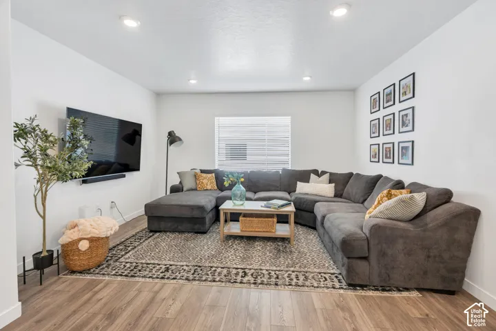 Recessed ceiling lighting, white walls, and wood-finish flooring