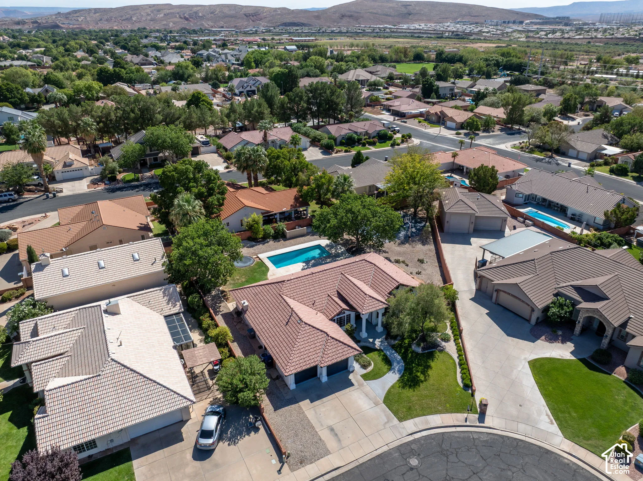 Residential community with mature landscaping, curvilinear streets, and mountain backdrop