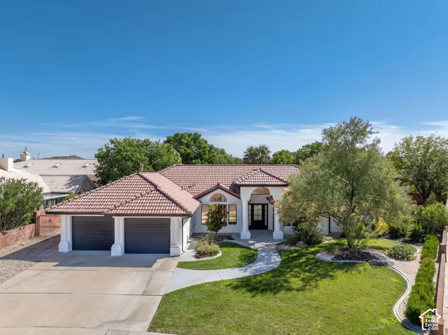 Single-story residence featuring a tile roof, an arched entry, and a two-car garage