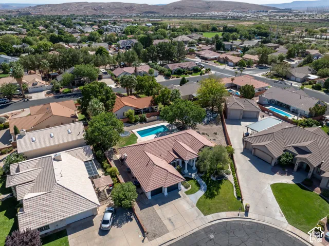 Residential community with mature landscaping, curvilinear streets, and mountain backdrop