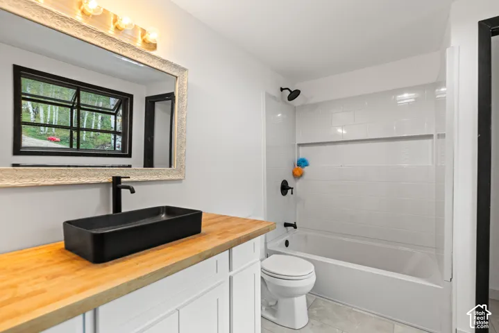 Vanity with wood-finish countertop, black rectangular vessel sink, and matte black faucet