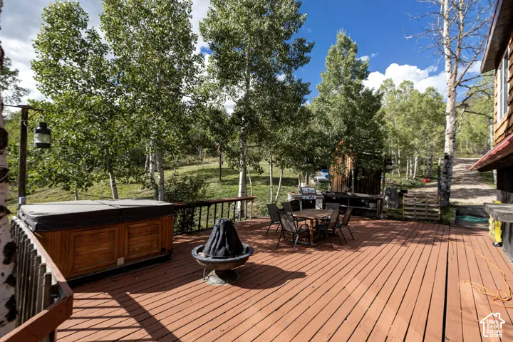 Expansive wood-plank deck with a built-in spa, fire pit, and outdoor entertaining space