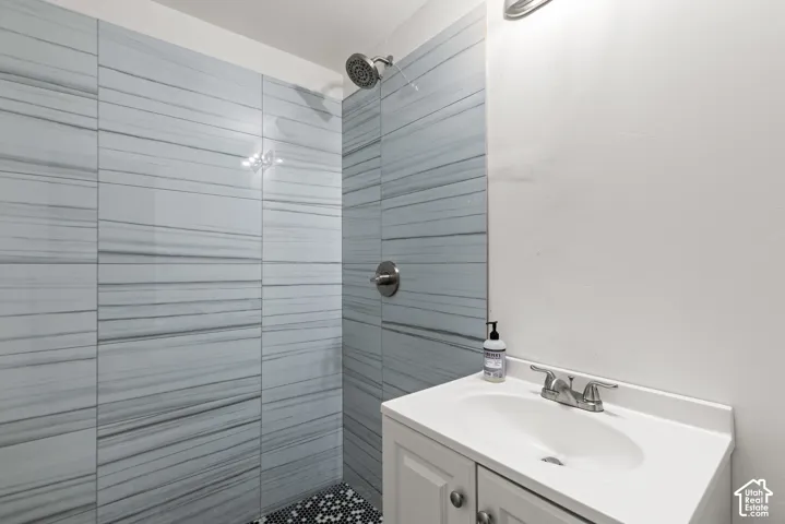 Shower featuring horizontally-oriented tiled walls and a rainfall showerhead