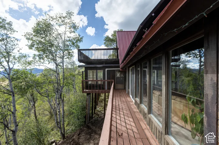 Expansive wood-finish deck with railing, offering multiple outdoor spaces