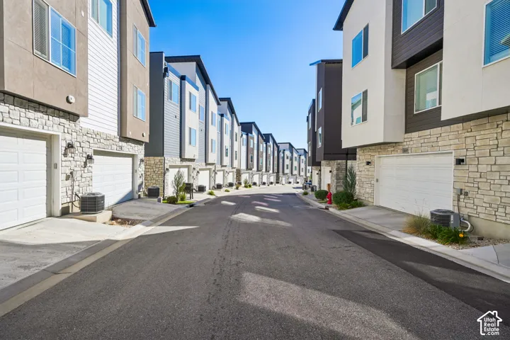 Contemporary multi-story exteriors with stone veneer accents, individual garage doors, and ample exterior lighting