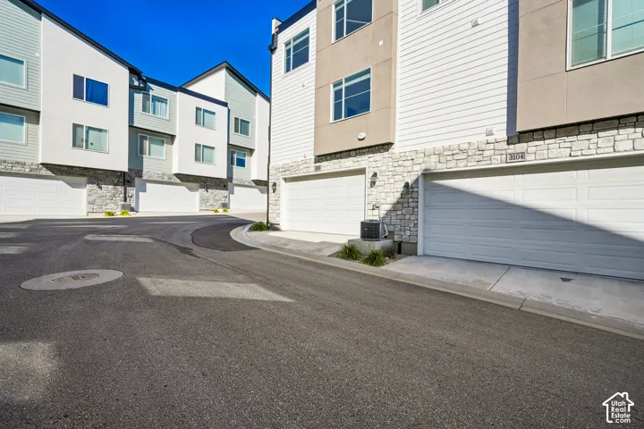 Modern townhome exteriors featuring white horizontal siding and stone accents