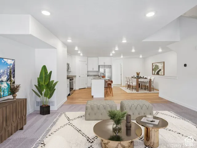 Recessed lighting throughout, wood-finish flooring, white cabinetry, stainless steel appliances, and granite countertops