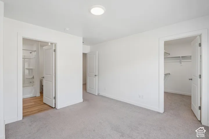 Neutral-toned carpeting, white walls, and a recessed ceiling light