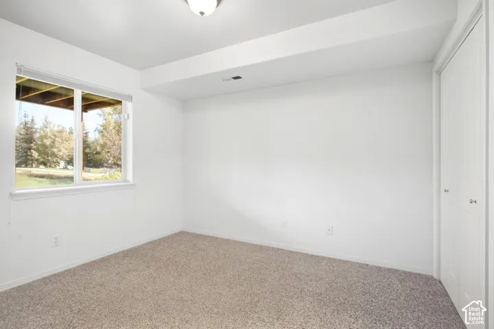 Carpeted flooring with white painted walls and a single window