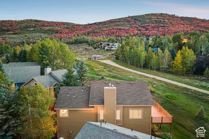 Property featuring a multi-level deck, two chimneys, and an exterior with natural siding