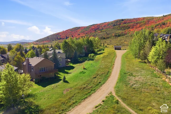 Hillside property with a natural terrain, featuring a dirt path and a small shed structure