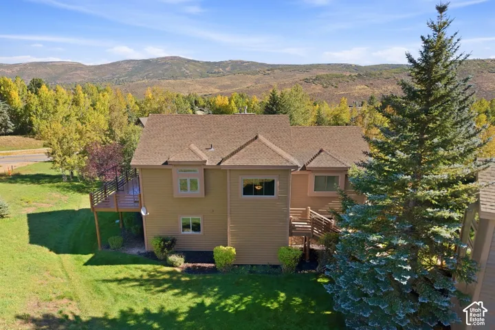 Exterior featuring wood siding, a multi-level deck, and a pitched roof